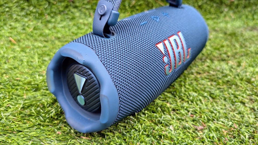 JBL Charge 6 lying on grass, showing the woven grille